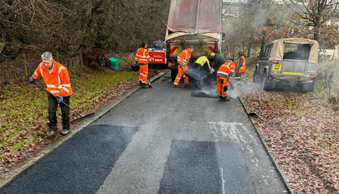 Armstrong's Surfacing tarmacadam gang working on private road repair work in Scotland